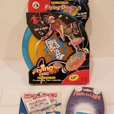 Lot 277:  New Flying Disk, Monopoly Keychain Game & Flashlight