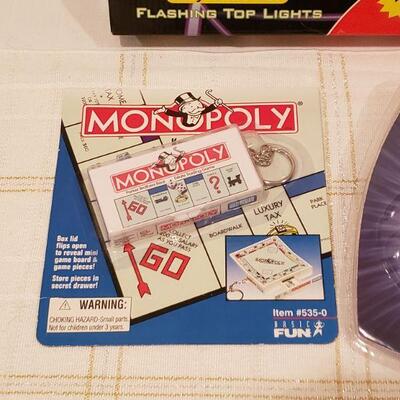 Lot 277:  New Flying Disk, Monopoly Keychain Game & Flashlight