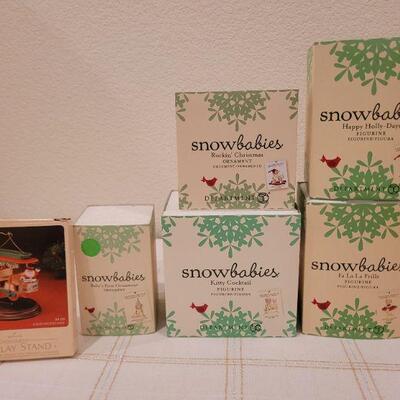Lot 717: Assorted Dept 56 Snowbabies Christmas Figures + Ornament Stand