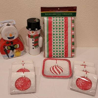 Lot 138: NEW Christmas Cheer Kitchen Lot- 6 Packages of Disposable Napkins,  Disposable Plates, Tablecloth & Snowman Tins