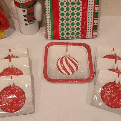 Lot 138: NEW Christmas Cheer Kitchen Lot- 6 Packages of Disposable Napkins,  Disposable Plates, Tablecloth & Snowman Tins