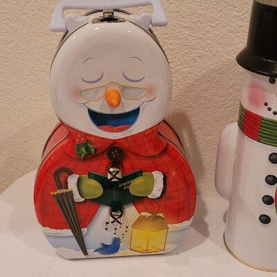 Lot 138: NEW Christmas Cheer Kitchen Lot- 6 Packages of Disposable Napkins,  Disposable Plates, Tablecloth & Snowman Tins