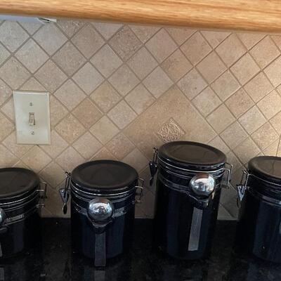4 black canisters with spoons