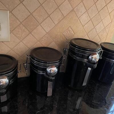 4 black canisters with spoons