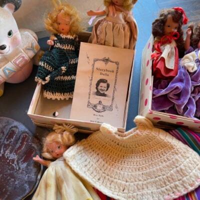 Lot 63. Vintage baby accessories; brushes, handprints in lay; 5 Storybook dolls and dresses; puppet, blanket, vases, vintage greeting...