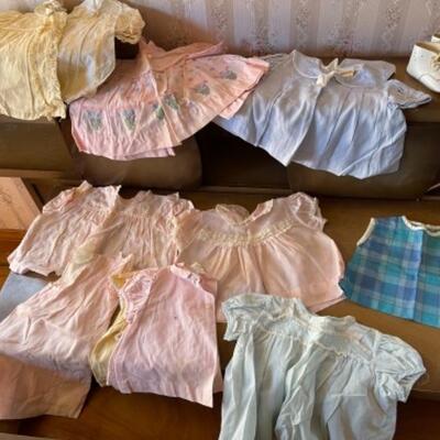 Lot 74. Vintage baby and doll clothes/1960sâ€”dresses, jackets, crochet/knit sweaters, bonnets, plastic diaper covers, pajamas, shoes,...