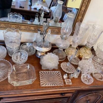 Lot 13. Assorted glassware, salt and pepper shakers, hurricane lamp, cut glass vase, cake plates, candy dish, condiment server, compote,...