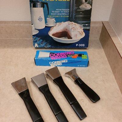 Lot 35: New Corning Ware Pie Plate and Handle in Boxes and (4) used Handles