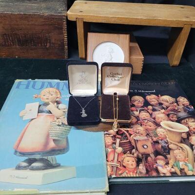 LOT# 71 TWO Hummel Collector's Books, TWO Necklaces, a Plaque, and a Stand. 
