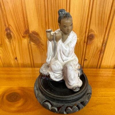 Oriental flute player statue  in porcelain on carved wooden stand 