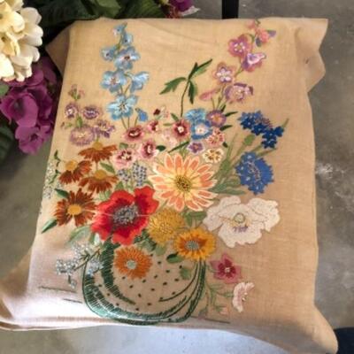 Lot 82. Two floral needlepoint canvases; silk flower arrangements in metal containers; one metal rectangle and one Japanese style...