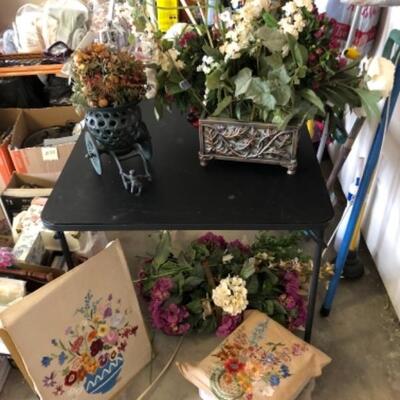 Lot 82. Two floral needlepoint canvases; silk flower arrangements in metal containers; one metal rectangle and one Japanese style...