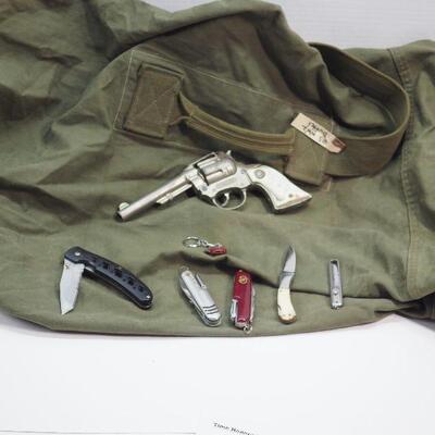Lot 103 Military Duffel bag and 6 pocket knives, 1 vintage Western cap gun