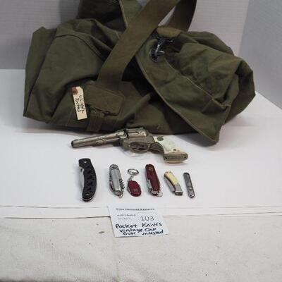 Lot 103 Military Duffel bag and 6 pocket knives, 1 vintage Western cap gun