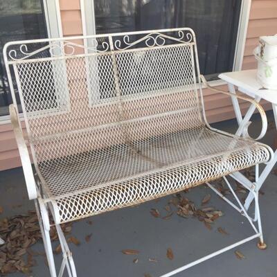 LOT #65. Vintage white wrought iron glider with cushions. 
