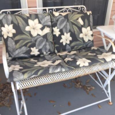 LOT #65. Vintage white wrought iron glider with cushions. 