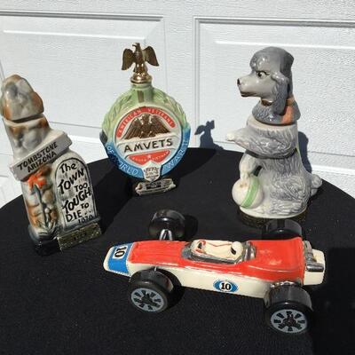 JIM BEAM Collection of four collectible bottles 12 to 14 inches with poodle and race car