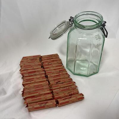 -94- 28 rolls of 95% copper pennies in a glass jar.