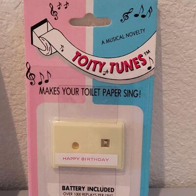 Lot 139: Pull Sting Music Box and (3)  Toity Tunes (makes your toliet paper sing)