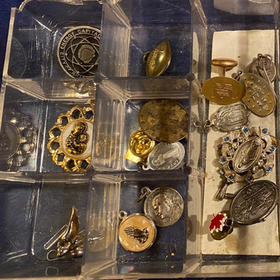 Box of religious metals and pins
