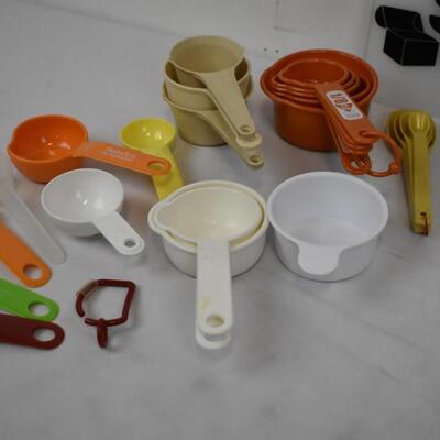 Bin of Kitchenware: Scrapers, Multi-Knife, Measuring Cups - Used, good condition