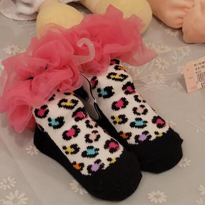 Lot 104: New Baby Girl Plushies, Praying Doll, Stroller Cover and Socks 