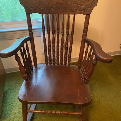 Antique wooden rocking chair with arm rests