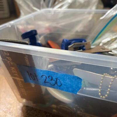 lot 230- box of misc. keys, keychains, dog door stopper, locks, bag of misc. toiletries 