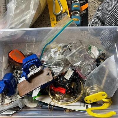 lot 230- box of misc. keys, keychains, dog door stopper, locks, bag of misc. toiletries 