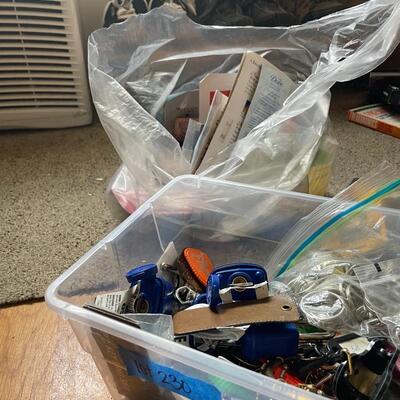 lot 230- box of misc. keys, keychains, dog door stopper, locks, bag of misc. toiletries 