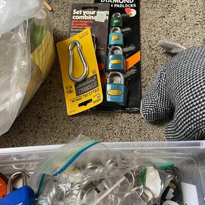 lot 230- box of misc. keys, keychains, dog door stopper, locks, bag of misc. toiletries 