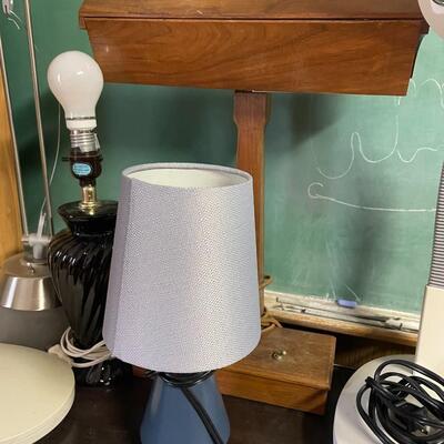 lot 256- Misc. lamps, black book case with contents, tall brown case