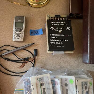 lot 295- TRS-80 buffs, digitizing pen, binders, cassettes, vintage phone, lamp, trashcan, etc.