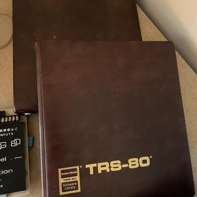 lot 295- TRS-80 buffs, digitizing pen, binders, cassettes, vintage phone, lamp, trashcan, etc.