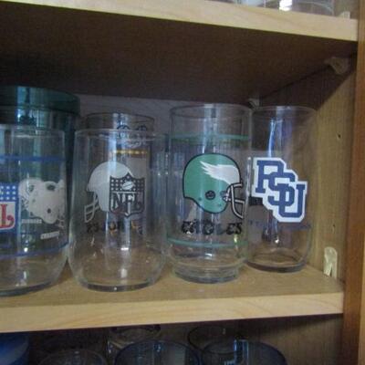 Cabinet Full of Mostly Sports Related Drinkware and Accessories