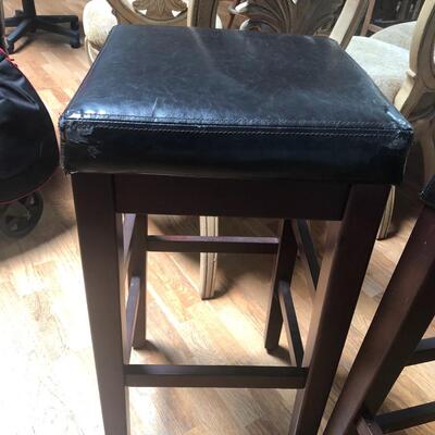 Two wood and faux leather barstools 