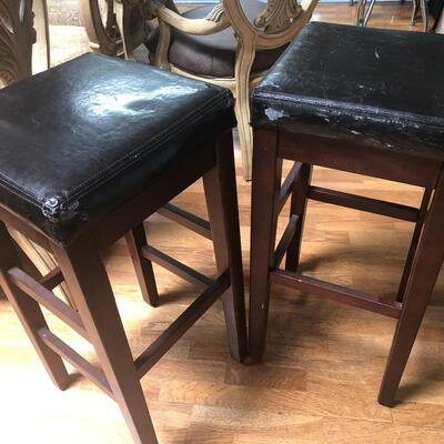Two wood and faux leather barstools 