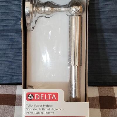 Lot 108: New in Package Delta Toliet Paper Holder with Chrome Finish