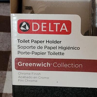 Lot 108: New in Package Delta Toliet Paper Holder with Chrome Finish