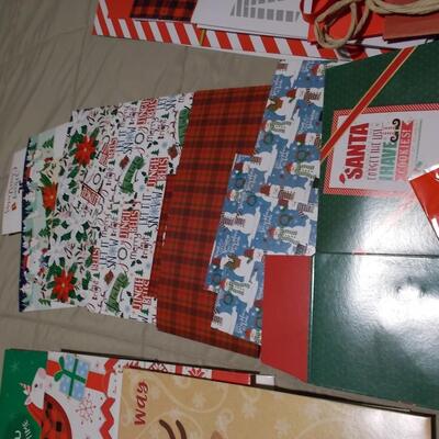 Large collection of holiday boxes, bags, tissue paper, and a bow maker. 
