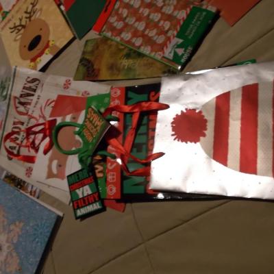 Large collection of holiday boxes, bags, tissue paper, and a bow maker. 
