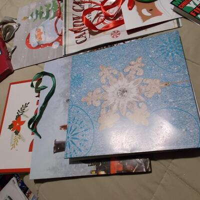 Large collection of holiday boxes, bags, tissue paper, and a bow maker. 