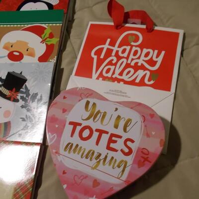 Large collection of holiday boxes, bags, tissue paper, and a bow maker. 
