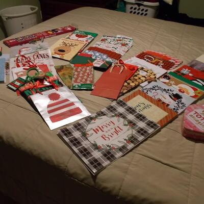Large collection of holiday boxes, bags, tissue paper, and a bow maker. 
