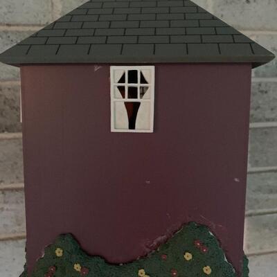 Array of birdhouses and white wooden trunk on casters.