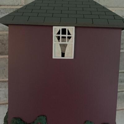 Array of birdhouses and white wooden trunk on casters.