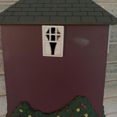 Array of birdhouses and white wooden trunk on casters.