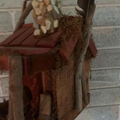 Array of birdhouses and white wooden trunk on casters.