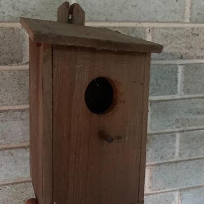Array of birdhouses and white wooden trunk on casters.