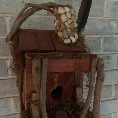 Array of birdhouses and white wooden trunk on casters.